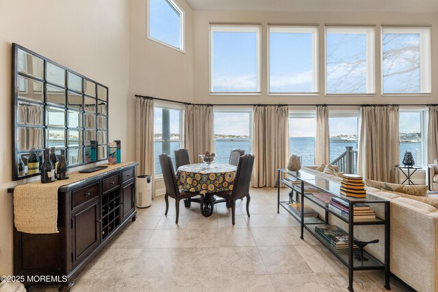 dining area featuring a high ceiling and a water view