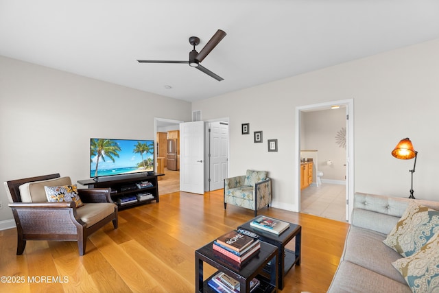 living room with baseboards, a ceiling fan, and wood finished floors