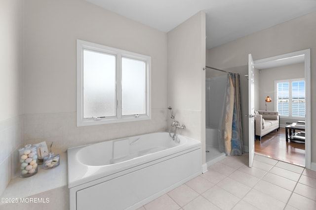 bathroom featuring a stall shower, a garden tub, and tile patterned floors