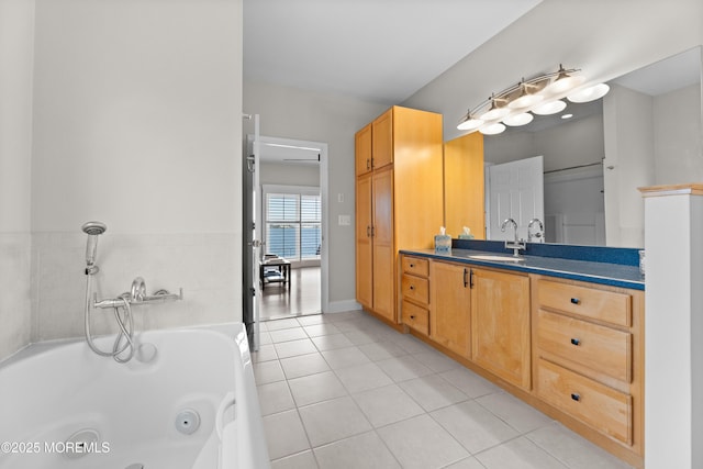 bathroom with a jetted tub, tile patterned flooring, and vanity