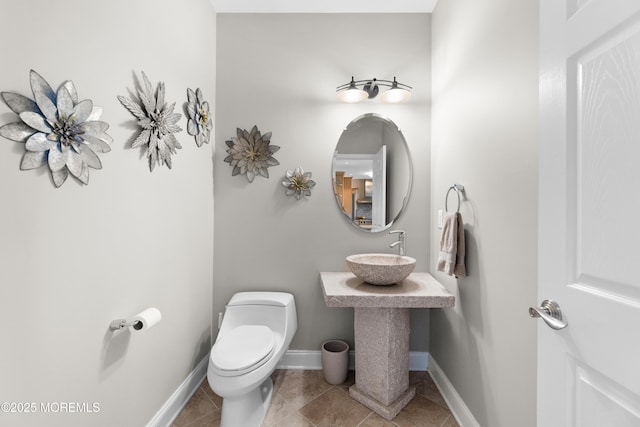 bathroom with tile patterned floors, a sink, toilet, and baseboards