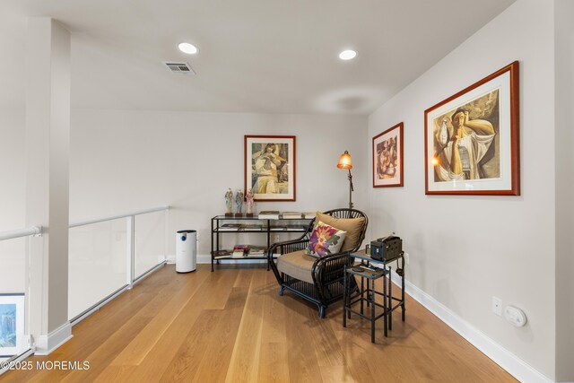 sitting room featuring baseboards, visible vents, wood finished floors, and recessed lighting