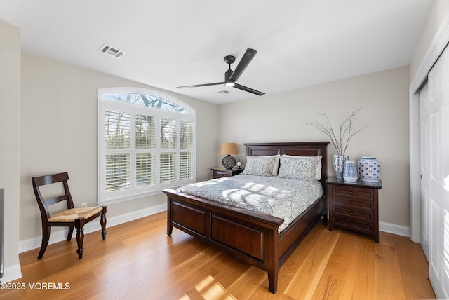 bedroom with a ceiling fan, visible vents, baseboards, a closet, and light wood finished floors