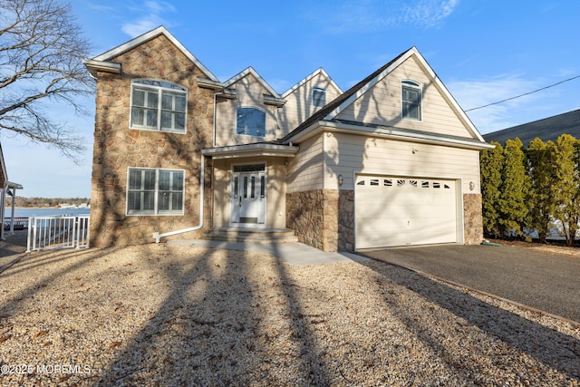 traditional-style house featuring aphalt driveway and stone siding