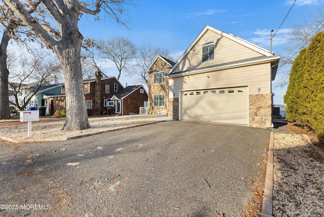 traditional home with aphalt driveway and stone siding