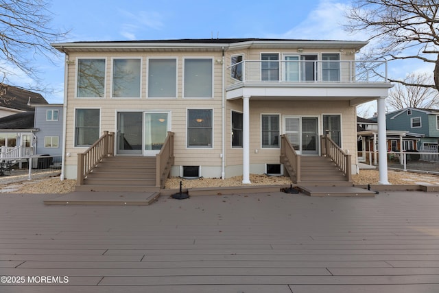 back of property featuring entry steps, central AC unit, and a balcony