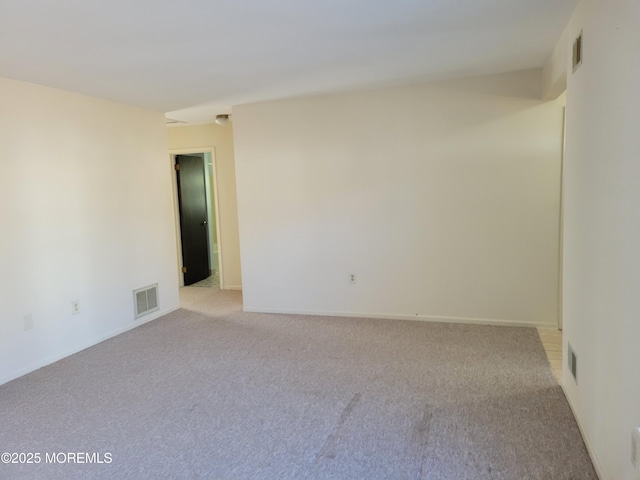 unfurnished room featuring visible vents, light carpet, and baseboards