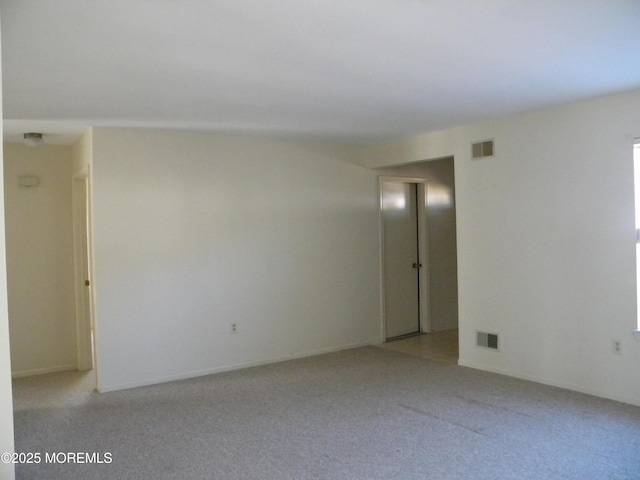 empty room with visible vents and light colored carpet