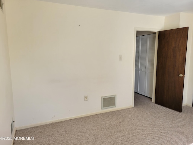 unfurnished bedroom with baseboards, a closet, visible vents, and carpet flooring