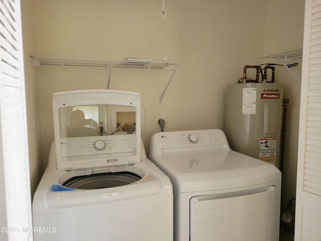 laundry room with water heater, laundry area, and separate washer and dryer