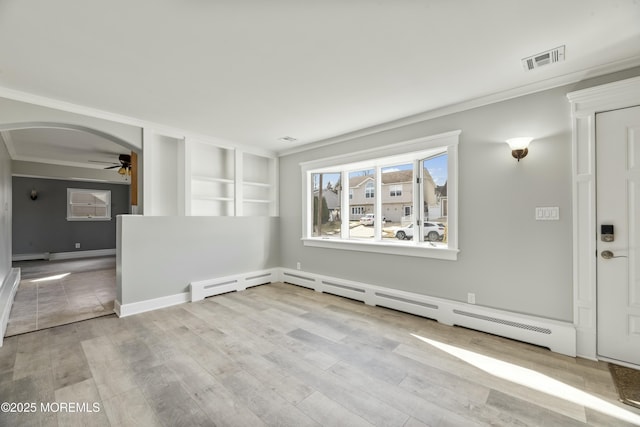 unfurnished room featuring light wood-style floors, arched walkways, visible vents, and ornamental molding