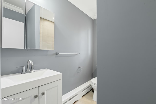 bathroom with crown molding, toilet, baseboard heating, vanity, and baseboards