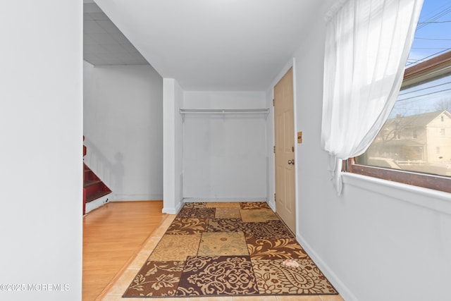 hallway featuring wood finished floors and baseboards