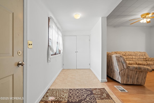 entrance foyer with light tile patterned floors, a ceiling fan, visible vents, and baseboards