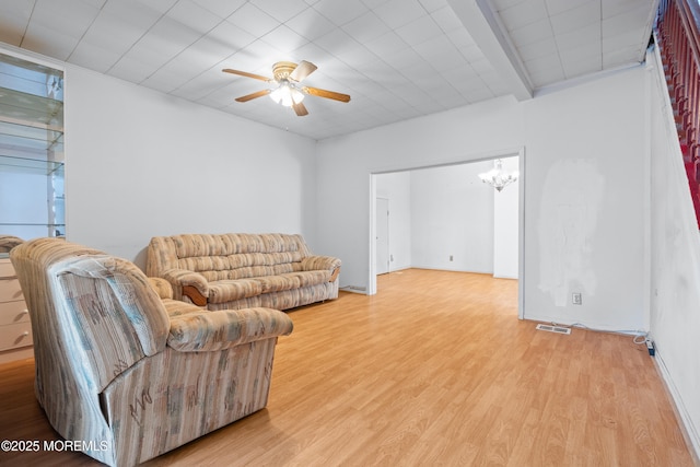 living room with light wood finished floors, visible vents, and ceiling fan with notable chandelier