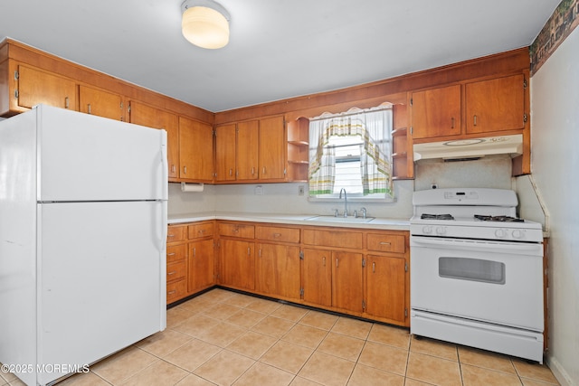 kitchen with under cabinet range hood, white appliances, a sink, light countertops, and brown cabinetry