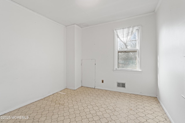 spare room with baseboards, visible vents, and crown molding