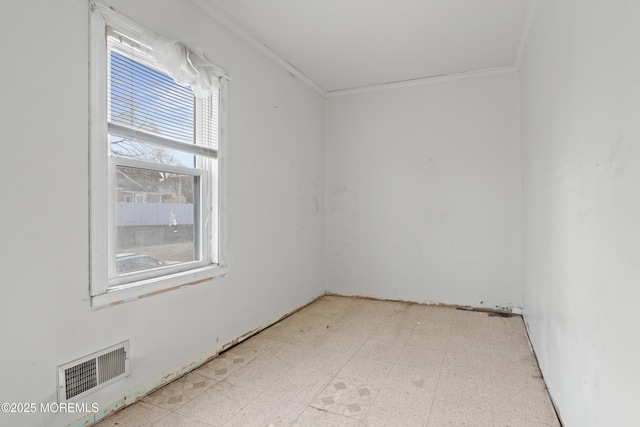 empty room with visible vents, crown molding, and tile patterned floors