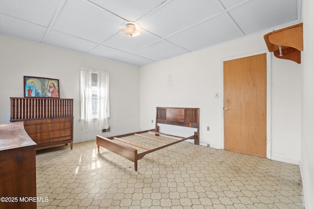 interior space featuring a paneled ceiling, baseboards, and tile patterned floors