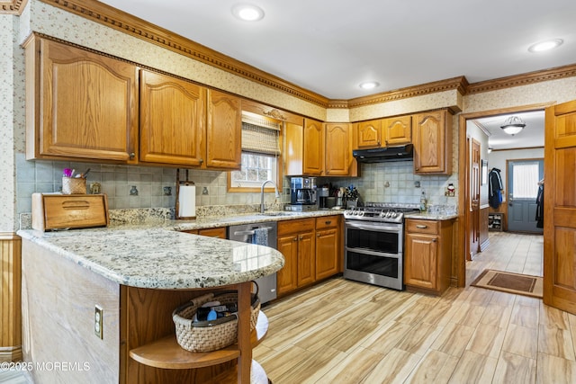 kitchen with under cabinet range hood, stainless steel appliances, a sink, open shelves, and brown cabinetry