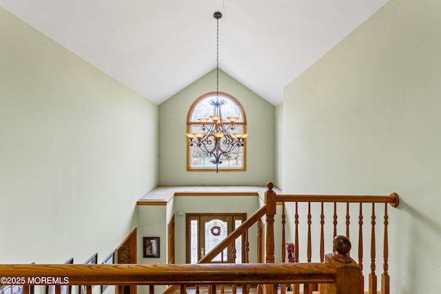 staircase featuring lofted ceiling and a notable chandelier