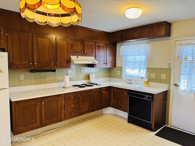 kitchen with white appliances, light floors, light countertops, under cabinet range hood, and a sink