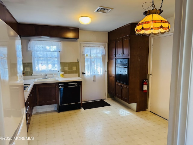 kitchen with visible vents, light floors, light countertops, black appliances, and a sink