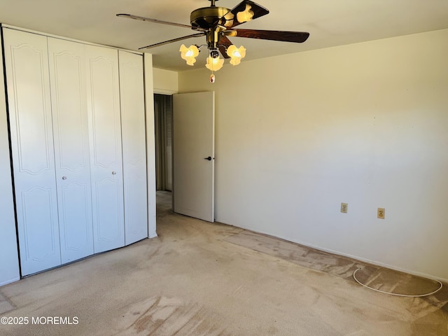 unfurnished bedroom with a closet, a ceiling fan, and light colored carpet