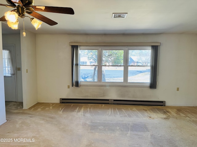 carpeted spare room featuring a healthy amount of sunlight, visible vents, and baseboard heating