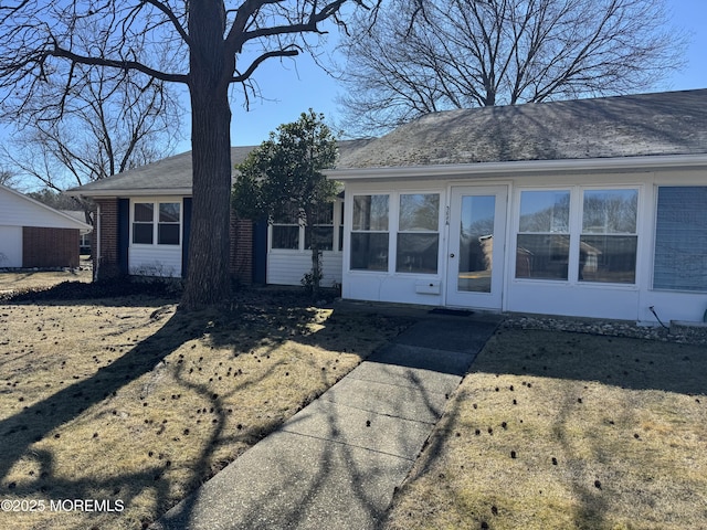 view of front of house with brick siding and a sunroom