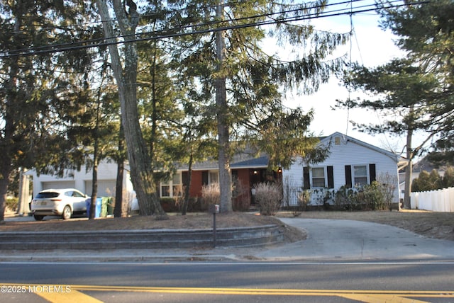 ranch-style home featuring a garage and fence