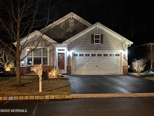 view of front of house featuring a garage, brick siding, and driveway