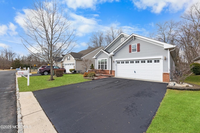 view of front of property featuring a garage, a front lawn, aphalt driveway, and brick siding