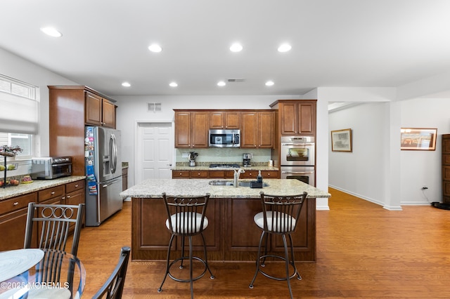 kitchen featuring a sink, stainless steel appliances, wood finished floors, and recessed lighting