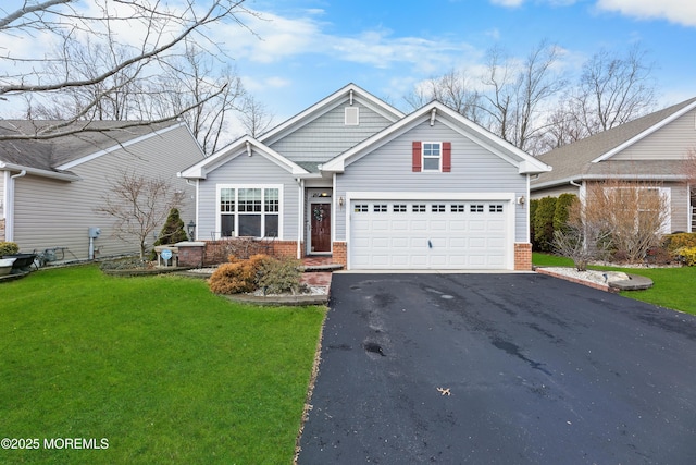 view of front of property with aphalt driveway, a front yard, and brick siding