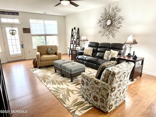 living area with visible vents, ceiling fan, baseboards, and wood finished floors