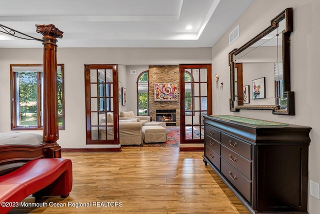 sitting room with visible vents, a stone fireplace, light wood-style flooring, and recessed lighting