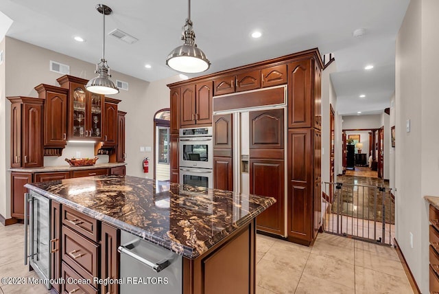 kitchen featuring double oven, beverage cooler, visible vents, and glass insert cabinets