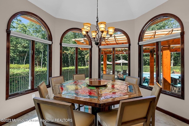 dining room with a notable chandelier, baseboards, and light tile patterned floors