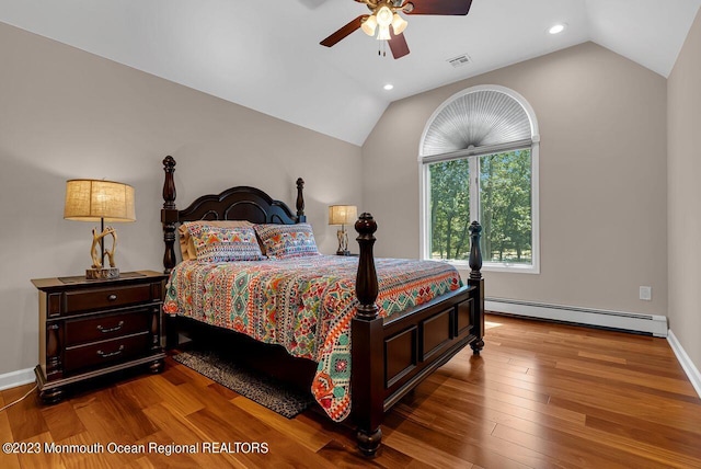 bedroom with lofted ceiling, visible vents, baseboard heating, a ceiling fan, and hardwood / wood-style floors