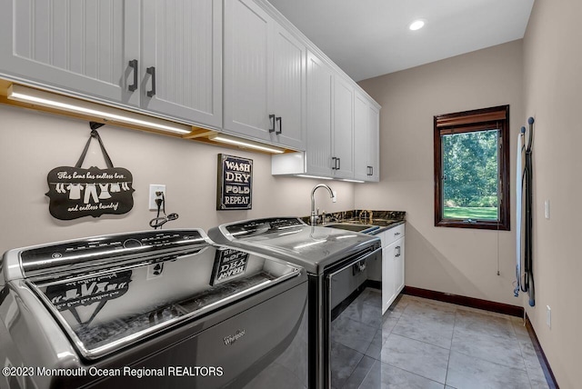 clothes washing area with cabinet space, baseboards, washing machine and dryer, a sink, and recessed lighting