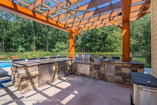 view of patio featuring a pergola, an outdoor kitchen, a grill, and fence