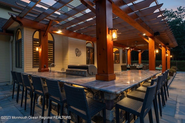 view of patio / terrace with exterior kitchen, outdoor wet bar, area for grilling, and a pergola