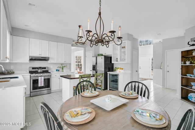 dining space featuring beverage cooler, light tile patterned flooring, and a notable chandelier