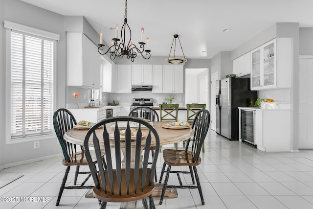 dining room with a healthy amount of sunlight, light tile patterned floors, wine cooler, and an inviting chandelier