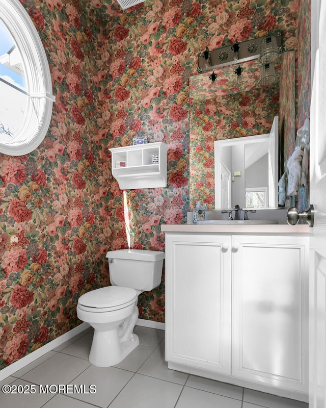 bathroom with wallpapered walls, baseboards, toilet, tile patterned floors, and vanity