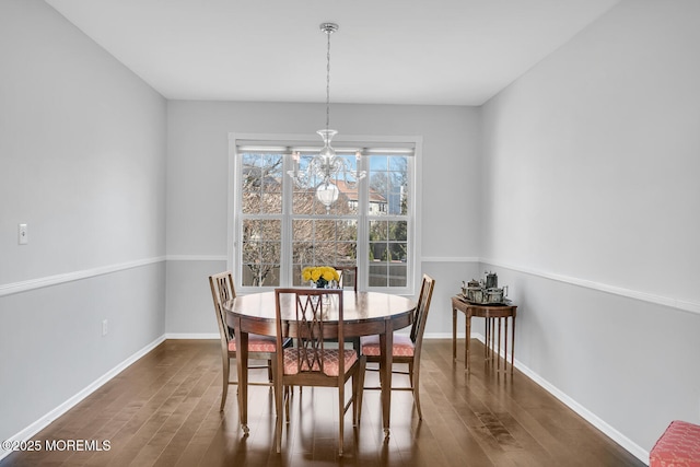 dining room featuring an inviting chandelier, dark wood finished floors, and baseboards