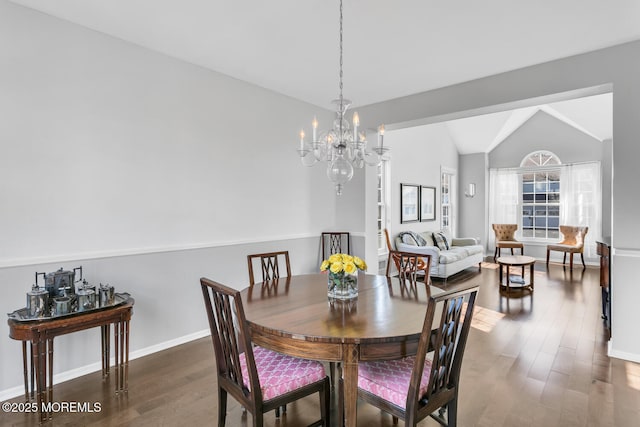 dining area with vaulted ceiling, baseboards, wood finished floors, and a chandelier