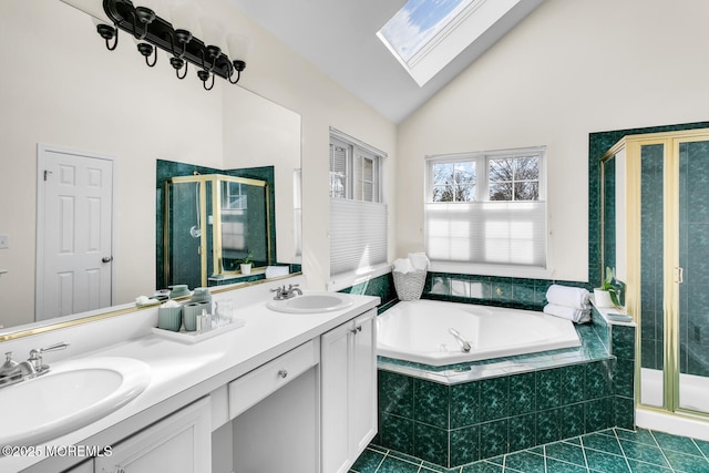 bathroom with a garden tub, vaulted ceiling with skylight, a sink, and a shower stall