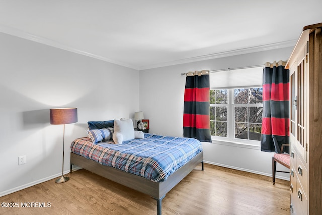 bedroom with crown molding, baseboards, and wood finished floors